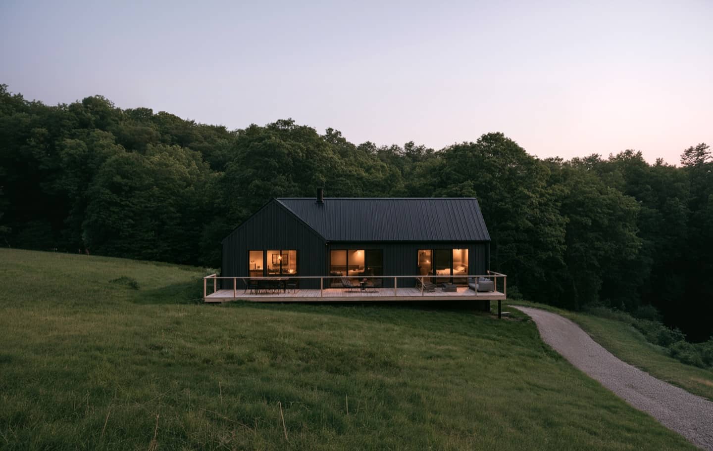 Modern house with warm lit windows at dusk