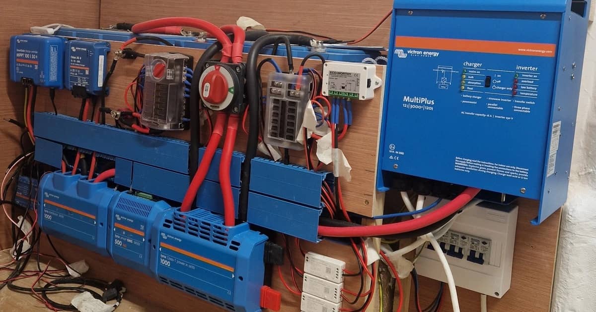 Victron inverter/charger, solar chargers and busbars mounted on an RV wall